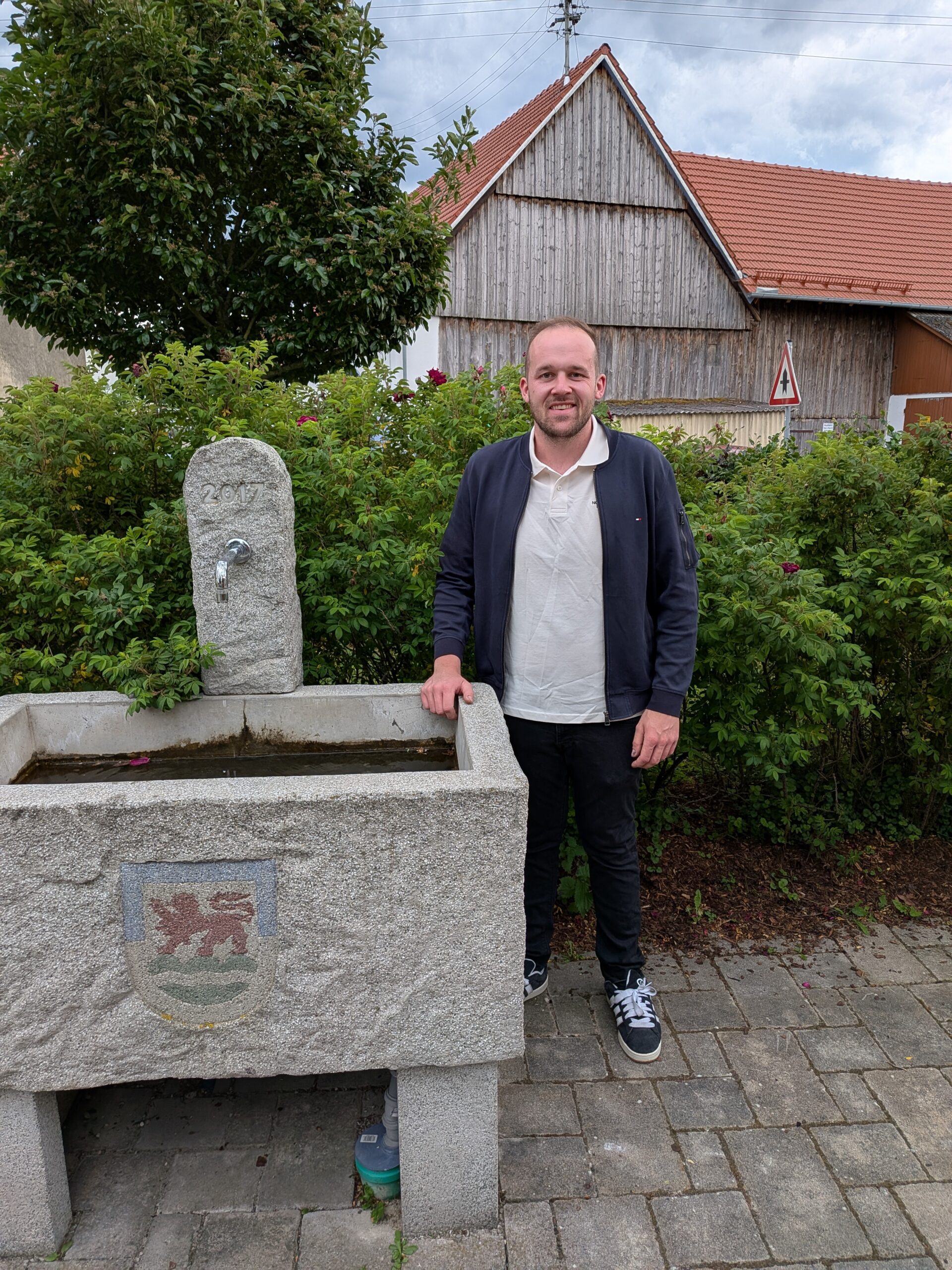 Person steht hinter einem Brunnen